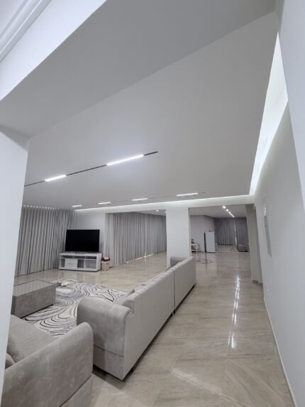 Living room with modern gypsum ceiling and cove lighting after renovation